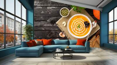 Funny food for Halloween. Pumpkin puree soup, spider web, dark old wooden table, top view, copy space Wall mural