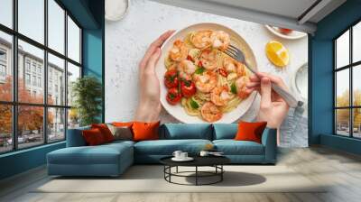 Pasta bavette with fried shrimps, bechamel sauce. Woman hands in frame, girl eats pasta, top view Wall mural