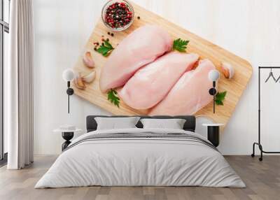 raw chicken breast fillet with spices on a wooden board on white wooden table, top view Wall mural