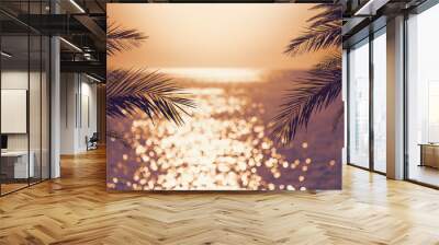 Blur beautiful nature green palm leaf on tropical sunset beach with bokeh light wave abstract background. Wall mural