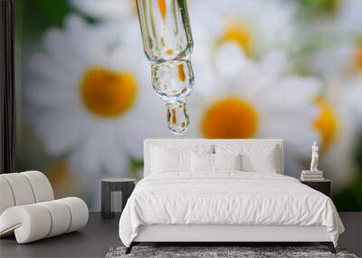 drop of chamomile cosmetic oil flows from the pipette on a background of white medicinal flowers and is reflected in it on a summer Sunny meadow Wall mural