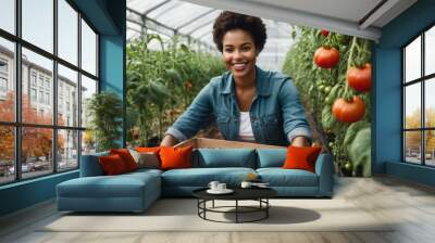 A woman gathers ripe tomatoes in a greenhouse, the abundance of the crop evident in her crate. Wall mural