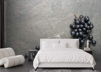 Empty wine glass and black grapes on stone table surface flat lay background. Wall mural