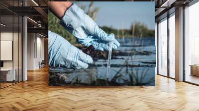 Water pollution concept. Woman scientist takes a water sample from polluted pond. Wall mural