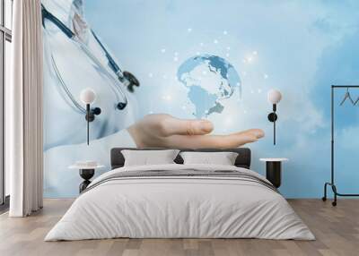 A female doctor with a stethoscope on her neck is holding a crystal, sparkling global map on her hand . Wall mural