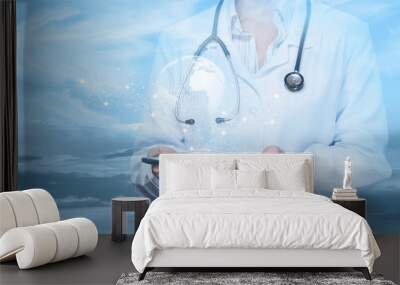 The doctor works on a mobile device in a network against the sky. Wall mural