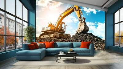 A yellow excavator digging and moving earth at a construction site under a bright blue sky with clouds and sunlight. Wall mural