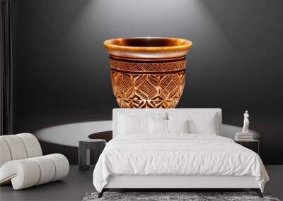 Beautiful carved glass cup with intricate patterns illuminated against a dark background
 Wall mural