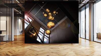 Beautiful golden chandeliers in a dark room. Wall mural