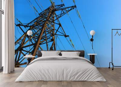 High voltage transmission tower line against blue sky, bottom view. iron construction. Wall mural