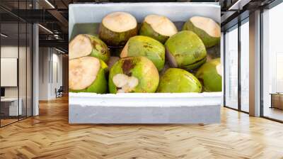 Chilled coconuts lie in ice water at the market. Delicious fresh coconut water Wall mural