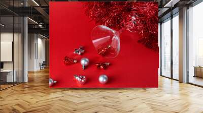 Christmas silver and red toys in a glass goblet on a red background
 Wall mural