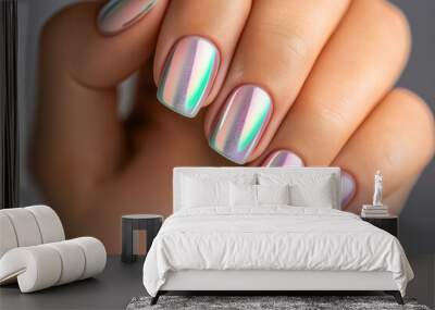 Close-up of a hand with manicured nails painted with an iridescent, holographic polish in shades of pink, purple, and green. Wall mural