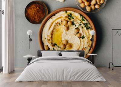 Large bowl of homemade hummus garnished with chickpeas, red sweet pepper, parsley and olive oil Wall mural