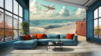 Vintage suitcase on sandy beach with airplane overhead Wall mural