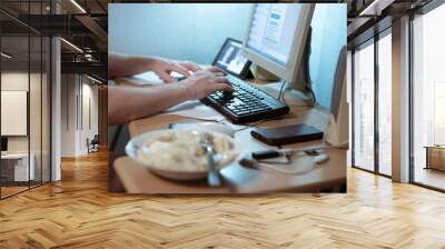 man typing on a keyboard at a computer desk, remote work at home Wall mural