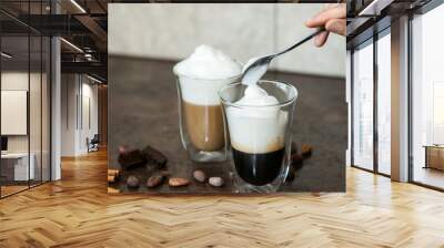 Milk foam is put in a coffee. Wall mural