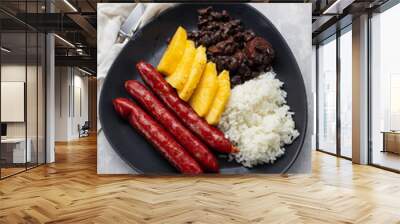 sausages with rice, black beans, and pineapple on dark dish Wall mural