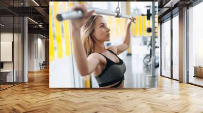 Pretty young woman training in the gym Wall mural