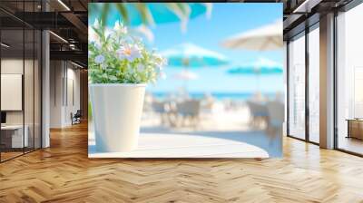 Relaxing beachside cafe terrace with sandy beige chairs and blue umbrellas under a bright sunny sky Wall mural