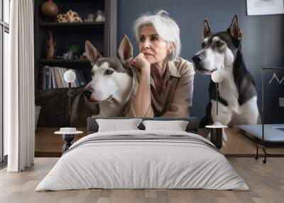 shot of a woman sitting in her office with her two dogs Wall mural