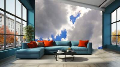 Two large fluffy white clouds against a blue sky. Template for text, natural airy background Wall mural