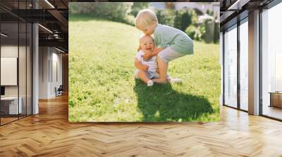 Happy children play on nature outdoors. Brother and sister. Wall mural