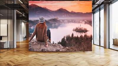 traveling young woman looking on sunset on bled lake, slovenia, europe Wall mural