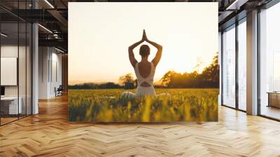 Young woman practicing yoga on nature. Wall mural