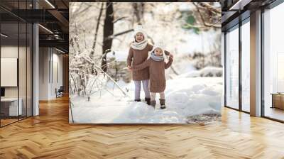 Children friends play among snowdrifts together. Wall mural