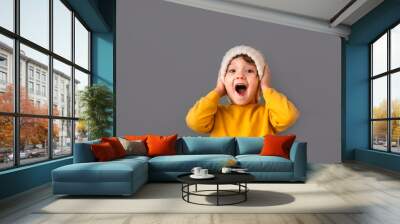 Funny caucasian child in yellow and hat on gray Wall mural