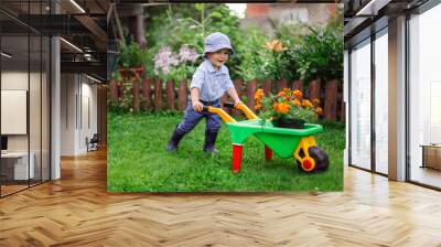 Little gardener, child plant flower in garden Wall mural