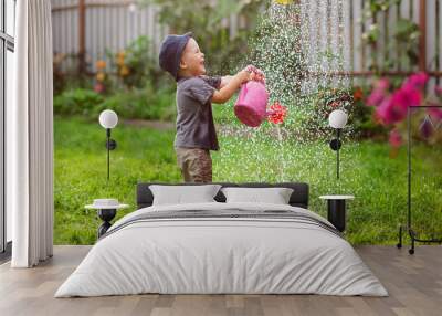 Mom and boy child water the garden together joke Wall mural