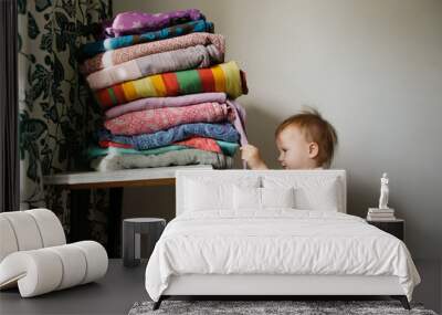 Toddler kid next to a stack of slings, Wall mural