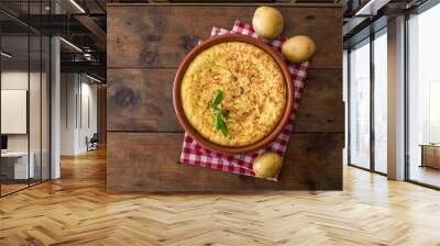 Spanish potato omelet called tortilla de patatas on a rustic wooden texture with a place for text. Wall mural