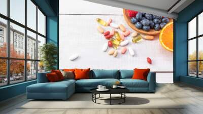 A top view of fresh fruits and vegetables with different medicine on a wooden table Wall mural