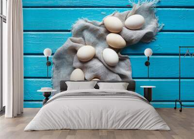 The raw eggs lie on a cloth on a wooden blue table. Wall mural