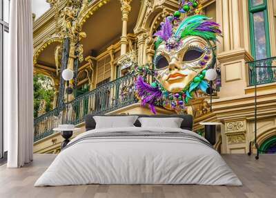 Large decorative carnival mask with vibrant feathers and beads, hanging on the facade of an ornate building, evoking a festive and cultural atmosphere Wall mural