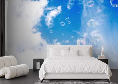 Soap multi-colored bubbles against a background of blue sky with clouds Wall mural