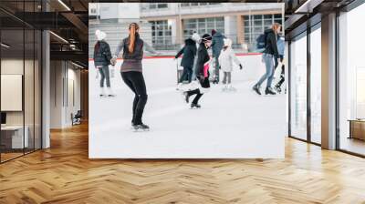 Soft,Selective focus.People, friendship, sport and leisure concept - happy friends on skating rink.Group of teenage friends ice skating on an ice rink Wall mural