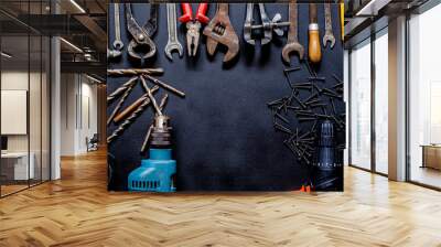 Tools for repair and reconstruction in home conditions lie on a black background Wall mural