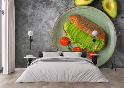 Vegan sandwich with avocado and tomatoes on a plate, on a gray background Wall mural