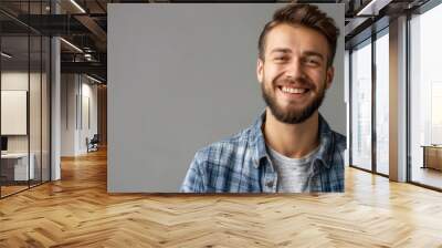 A man with a beard and a blue plaid shirt is smiling. He is wearing a gray shirt. Happy man adult face caucasian isolated background handsome confidence portrait casual attractive guy young person Wall mural