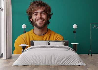 A man with a beard and a yellow sweater is smiling. He is posing for a picture. Scene is happy and friendly Wall mural