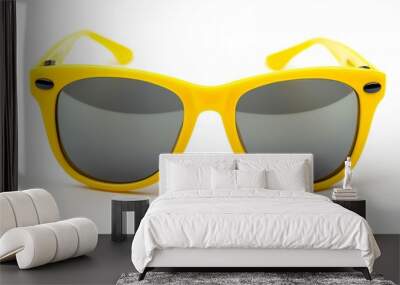 A pair of yellow sunglasses with a black frame. The sunglasses are on a white background Wall mural