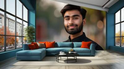 A Pakistani man wearing glasses and a suit is smiling for the camera. The image has a warm and friendly mood, as the man is happy and confident. profile picture of Pakistani guy smiling Wall mural