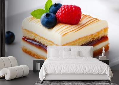 A slice of cake with blueberries and raspberries on top. The cake is cut into squares and is sitting on a white plate Wall mural