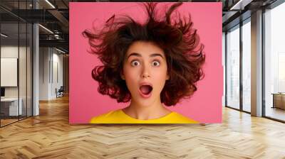 A woman with a messy hairdo and a surprised expression on her face. Concept of chaos and disarray, as if the woman's hair has been blown around by a strong gust of wind Wall mural