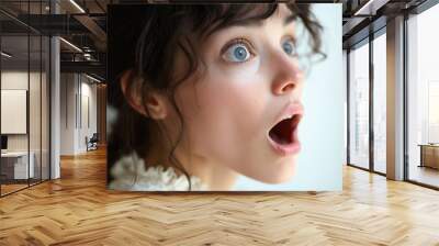 A woman with blue eyes and a surprised expression. She has her mouth open and her hair is in a bun Wall mural