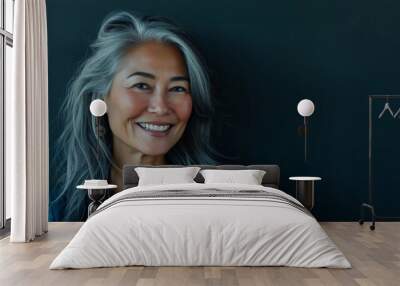 Happy smiling stylish confident 50 years old Asian female professional standing looking at camera at gray background. Portrait of sophisticated grey hair woman advertising products. Wall mural